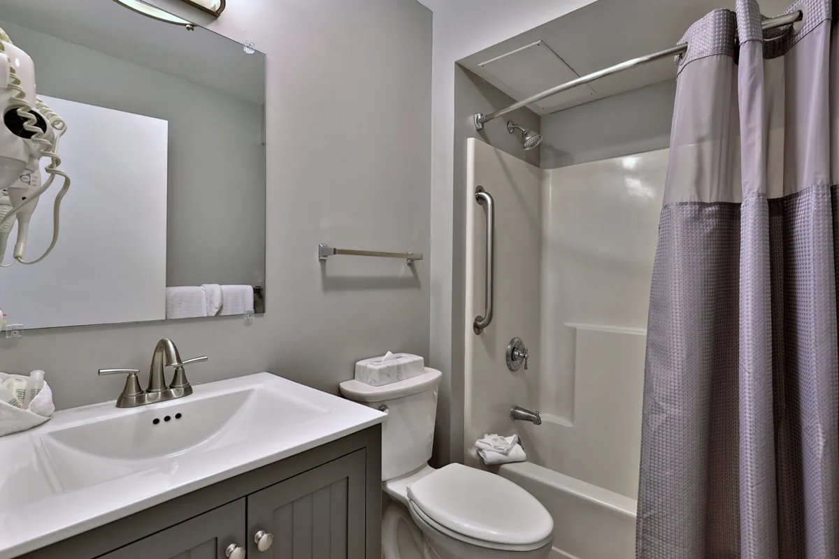 A fresh, spa-inspired bathroom featuring a modern sink, a spacious glass-enclosed shower, and a well-lit mirror. The clean lines and bright setting evoke relaxation and self-care.